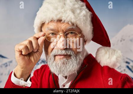 Portrait du Père Noël touchant ses lunettes et regardant directement la caméra, Joyeux Noël Banque D'Images
