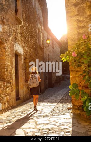 Une jeune promenade touristique dans la ville médiévale de Pals, les rues du centre historique au coucher du soleil, Gérone sur la Costa Brava de Catalogne dans la Méditerranée Banque D'Images