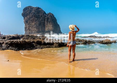 Un jeune touriste avec un chapeau dans la Roque del Moro de la plage de Cofete du parc naturel de Jandia, Barlovento, au sud de Fuerteventura, îles Canaries. Banque D'Images