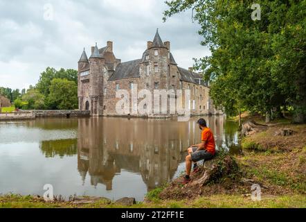 Un jeune homme au bord du lac Château médiéval Trecesson, commune de Campeneac dans le département du Morbihan, près de la forêt de Brocéliande Banque D'Images