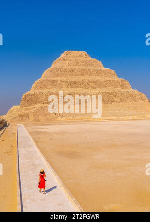 Une jeune femme visitant la Pyramide à gradins de Djoser, Saqqara. Égypte. La nécropole la plus importante de Memphis. La première pyramide au monde Banque D'Images