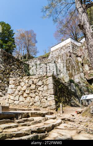 Château japonais au sommet de la montagne, Bitchu Matsuyama. Fondations de la porte d'entrée avec diverses terrasses de murs de pierre ishigaki et fondations de tourelle. Banque D'Images