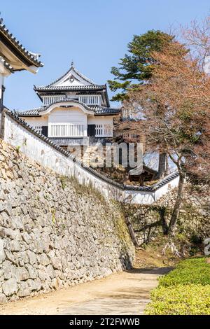 Château Bitchu Matsuyama au Japon. Le Nino maru, composé extérieur passant devant le mur de pierre ishigaki surmonté de murs de plâtre dobei, et le donjon. Banque D'Images