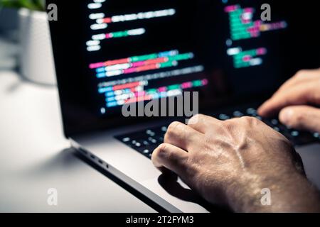 Pirate avec code malveillant dans l'écran de l'ordinateur. Cybersécurité, confidentialité ou cyberattaque. Programmeur ou fraude criminelle écrivant un logiciel de virus. Banque D'Images