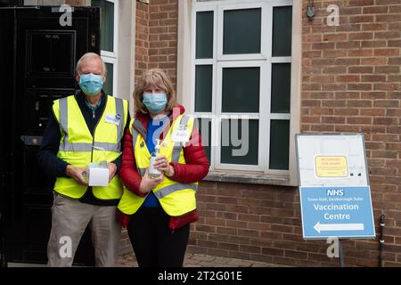 Maidenhead, Berkshire, Royaume-Uni. 19 octobre 2023. Les bénévoles accueillent les personnes qui arrivent à la suite Desborough à la mairie de Maidenhead, dans le Berkshire, pour avoir leurs coups de grippe et leurs coups de rappel Covid-19. Le nombre de patients dans les hôpitaux testant positivement pour Covid-19 a atteint un sommet de cinq mois. En dehors de celles qui ont des problèmes de santé spécifiques, les personnes de moins de 65 ans en Angleterre ne sont plus eligbile pour un rappel Covid-19, laissant une grande partie de la population en Angleterre vulnérable à attraper à nouveau Covid-19. Crédit : Maureen McLean/Alamy Live News Banque D'Images