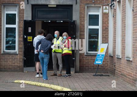 Maidenhead, Berkshire, Royaume-Uni. 19 octobre 2023. Les bénévoles accueillent les personnes qui arrivent à la suite Desborough à la mairie de Maidenhead, dans le Berkshire, pour avoir leurs coups de grippe et leurs coups de rappel Covid-19. Le nombre de patients dans les hôpitaux testant positivement pour Covid-19 a atteint un sommet de cinq mois. En dehors de celles qui ont des problèmes de santé spécifiques, les personnes de moins de 65 ans en Angleterre ne sont plus eligbile pour un rappel Covid-19, laissant une grande partie de la population en Angleterre vulnérable à attraper à nouveau Covid-19. Crédit : Maureen McLean/Alamy Live News Banque D'Images