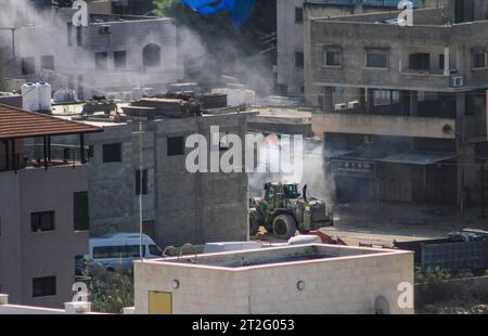 Tulkarm, Palestine. 19 octobre 2023. De la fumée s’élève d’un bulldozer militaire israélien blindé après qu’un engin explosif artisanal planté par la résistance palestinienne ait explosé lors de la prise d’assaut israélienne de la ville palestinienne de Tulkarem, dans le nord de la Cisjordanie. Crédit : SOPA Images Limited/Alamy Live News Banque D'Images