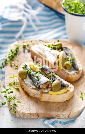 Sandwiches sardines sur un fond en bois blanc. Cuisine méditerranéenne Banque D'Images