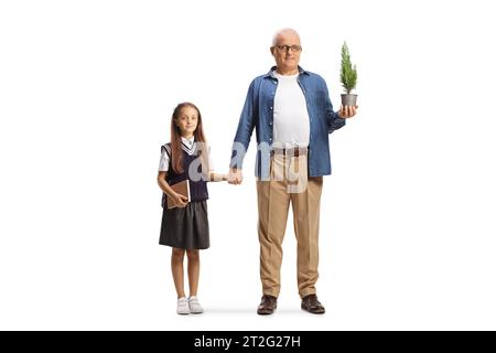 Portrait en longueur d'une écolière et d'un père tenant un petit arbre dans un pot isolé sur fond blanc Banque D'Images