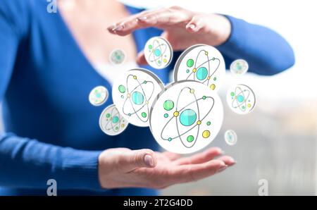 Concept de recherche nucléaire entre les mains d'une femme en arrière-plan Banque D'Images