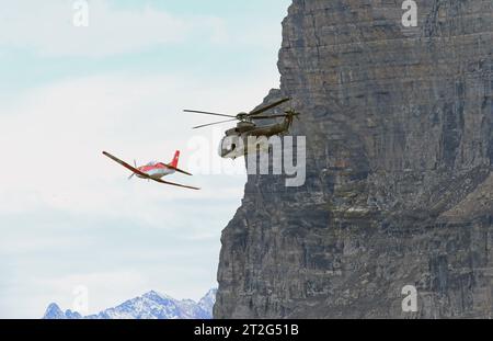 Ein Helikopter der Schweizer Luftwaffe vom Typ Aerospatiale AS-332 M1 Super Puma mit der Kennung T-314 im Rahmen eines Luftpolizei-Einsatzes. Erkennbar ein Schütze und ein Beobachter. DAS Feind-Darstellungflugzeug vom Typ Pilatus PC-7 mit der Kennung A-9 Flugvorführungen der Schweizer Luftwaffe auf dem Fliegerschiessplatz Axalp-Ebenfluh am 18. Oktober 2023. Axalp ob Brienz Kanton Bern Schweiz *** Un hélicoptère de l'armée de l'air suisse du type Aerospatiale AS 332 M1 Super Puma immatriculé T 314 dans le cadre d'une mission de police de l'air reconnaissable un tireur et un observateur l'ennemi affiche A. Banque D'Images