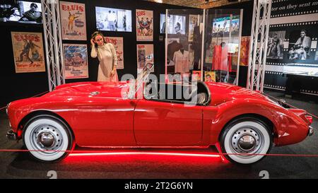 Londres, Royaume-Uni. 19 octobre 2023. Un visiteur pose avec la MGA 1600 MKI 1960 d'Elvis, la seule voiture personnelle d'Elvis qui a fini dans l'un de ses films, utilisé dans le film de 1961 'Blue Hawaii'. L'exposition « Direct from Graceland : Elvis » présente plus de 400 objets et objets emblématiques appartenant à Elvis, directement depuis la maison de l'icône Graceland à Memphis, Tennessee. L'exposition ouvre le 20 octobre au Arches London Bridge, à Bermondsey Street. Crédit : Imageplotter/Alamy Live News Banque D'Images