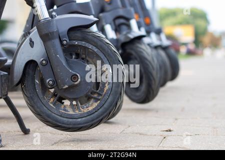 Les roues de nombreux scooters se tiennent sur le trottoir Banque D'Images