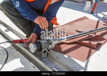 Un outil de surfaçage et d'équarrissage de tube est utilisé sur les tubes en acier inoxydable utilisés sur le toit de l'installation de réfrigération industrielle de CO2. Banque D'Images