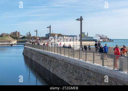 Personnes marchant sur Curtain Moat Pedestrian Bridge, Old Portsmouth, Hampshire, Angleterre, Royaume-Uni, sur le sentier Millennium Promenade Banque D'Images