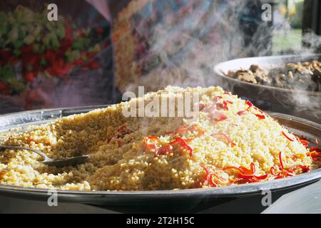 Bulgur pilaf fraîchement cuit au four. Fumez sur du riz bulgur sur un grand plateau Banque D'Images