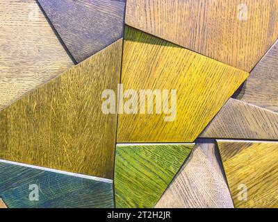 texture brillante, fond. Les triangles en bois sont peints en différentes couleurs. panneau sur le mur. éléments décoratifs à l'intérieur. Banque D'Images