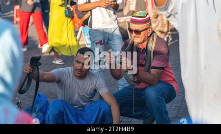 Marrakech, Maroc - 15 septembre 2022 : charmeur de serpents sur la place Jemaa el Fnaa dans la vieille ville de Marrakech. La place est pleine de nombreux touristes ac Banque D'Images