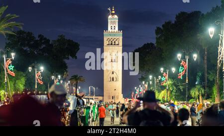 Marrakech, Maroc - 15 septembre 2022 : Minaret de la mosquée Koutoubia situé dans le quartier de la médina la nuit vu du centre-ville bondé. Ce sont les grands Banque D'Images