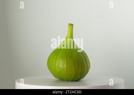 Figue verte fraîchement cueillie sur fond blanc sur le dessus du piédestal horizontal Ficus carica Banque D'Images