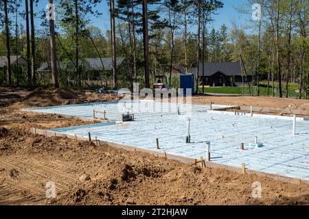 CROW WING CO, MN - 10 MAI 2023 : partie d'un chantier de construction de maison avec isolation sur le sol en béton, sur un beau terrain à bâtir dans un nouveau d Banque D'Images