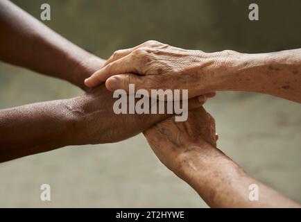 Gros plan sur des personnes âgées qui mettent les mains ensemble. Amis avec pile de mains montrant se soutenir mutuellement Banque D'Images