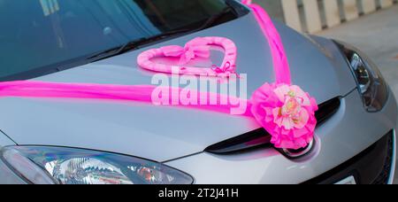 Belle voiture de mariage. L'avant de la voiture est décoré de fleurs. Décoré avec des fleurs pour le mariage fleurs fraîches sur la voiture. Weddi coloré Banque D'Images