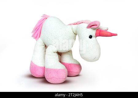 Image d'un jouet licorne souple rose assis sur fond blanc. Image de studio isolée. Photo de haute qualité Banque D'Images