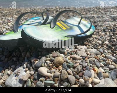 sandales bleues et seastars sur galets blancs par le rivage. Banque D'Images