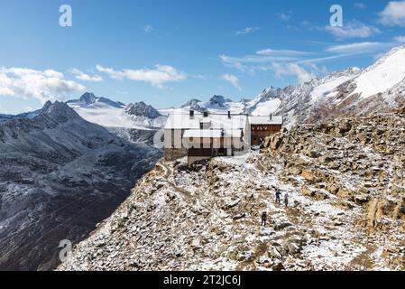 Groupe d'alpinistes partant de la cabane de montagne Ramolhaus au Ramoljoch en face des montagnes fraîchement enneigées des Alpes Oetztal Banque D'Images