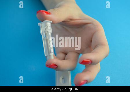 Mains d'un assistant de laboratoire dans des gants médicaux mettre un doigt sur le coton avec une goutte de sang, après avoir été pris pour analyse, closeup.Medical co Banque D'Images
