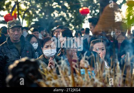 Les Vietnamiens allument des bâtons d'encens et prient à la pagode Tran Quoc à Hanoi, Vietnam à l'occasion du Têt, ou nouvel an lunaire. Banque D'Images