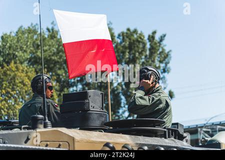 16.08.2023 Varsovie, Pologne. Deux soldats portant des casques militaires avec des écouteurs et un drapeau polonais flottant entre eux. Pologne et ses forces militaires. Photo de haute qualité Banque D'Images