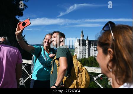 Les touristes prennent un selfie avec le château de Neuschwanstein dans le Allgäu bavarois près de Füssen, en Allemagne Banque D'Images