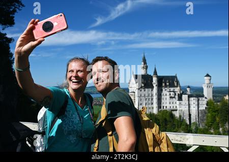 Les touristes prennent un selfie avec le château de Neuschwanstein dans le Allgäu bavarois près de Füssen, en Allemagne Banque D'Images