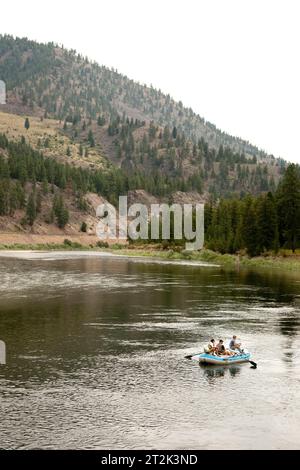 Trois personnes volent pêcher à partir d'un bateau dérivant. Banque D'Images