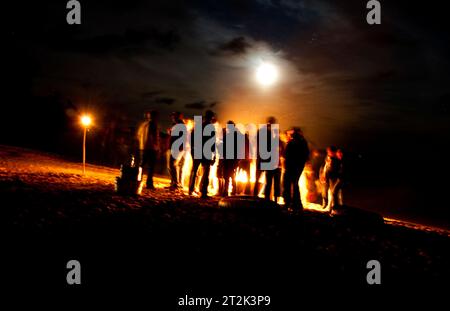 Un groupe s'est rassemblé autour d'un feu de camp sur la rive du lac Sebago. Banque D'Images