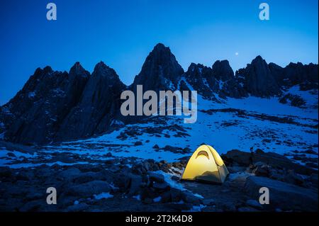 Tente illuminée la nuit avec le mont Whintey en arrière-plan, lac Iceberg, montagnes de la Sierra Nevada, Californie. Banque D'Images