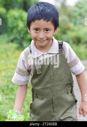 Joyeux garçon latin jouant dans une forêt dans les montagnes de Puebla. Banque D'Images