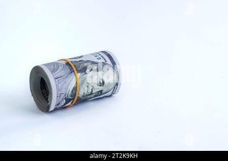 Dollars AMÉRICAINS enroulés et resserrés avec bande isolée sur fond blanc. Espace de copie. Mise au point sélective Banque D'Images