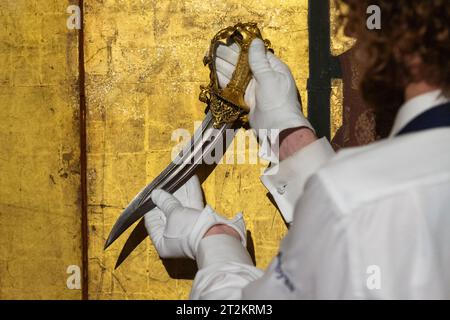 Londres, Royaume-Uni. 20 octobre 2023. Un technicien présente un ensemble de poignards zoomorphes dorés-cuivrés avec rubis et émeraudes, Inde, Deccan, Bijapur ou Golconda, fin du 16e siècle, (est. £200 000 - 300 000 ), lors d'un aperçu des prochaines ventes d'Arts of the Islamic World & India chez Sothebys. La vente aux enchères a lieu dans les galeries Sothebys New Bond Street le 25 octobre 2023. Crédit : Stephen Chung / Alamy Live News Banque D'Images