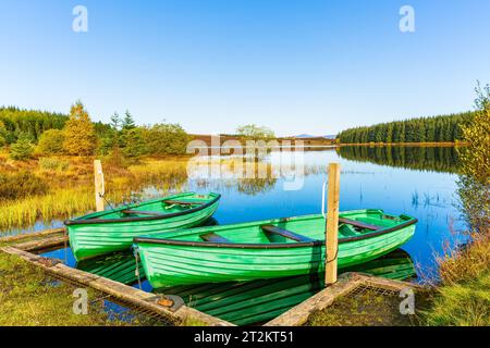 Le beau et serein Loch Kinardochy, Perth et Kinross, Écosse en automne avec deux bateaux de pêche verts pour les pêcheurs qui pêchent la truite brune. CL Banque D'Images