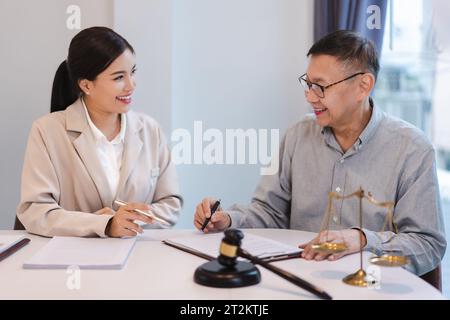 Avocat principal expliquant l'accord juridique avec la femme d'affaires et pointant sur le contrat pour la signature. Banque D'Images