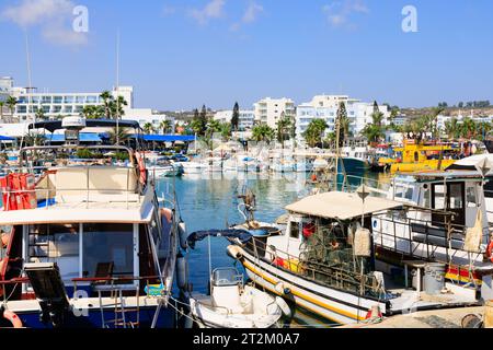 Bateau de pêche chypriote traditionnel amarré à côté des bateaux de plaisance touristiques dans le port d'Ayia Napa. Hôtels touristiques en arrière-plan. Chypre Banque D'Images