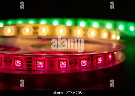 Canette avec rouleau d'éclairage LED incandescent placé sur la table, couleur rose, verte et blanche chaude Banque D'Images