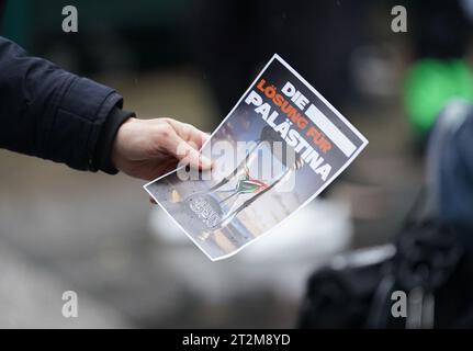 Hambourg, Allemagne. 20 octobre 2023. Un homme tient un dépliant indiquant « la solution pour la Palestine » devant une mosquée après les prières du vendredi. Après l'attaque terroriste du Hamas contre Israël le 7 octobre 2023, de nombreuses réactions ont eu lieu dans toute l'Allemagne. Crédit : Marcus Brandt/dpa/Alamy Live News Banque D'Images