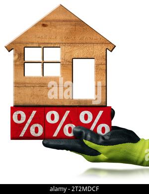 Travailleur manuel avec des gants de travail de protection tenant des signes de pourcentage rouge et blanc en blocs de bois avec une petite maison modèle en bois sur le dessus. ISO Banque D'Images