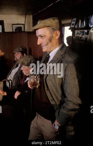 Les agriculteurs et les compatriotes se réunissent au Kings Head, et aussi connu sous le nom de Low House pub, à Laxfield Suffolk, Royaume-Uni. Les récits traditionnels, la récitation de poésie et les chansons de musique folklorique sont joués de manière informelle tous les dimanches matin. Tony Harvey, qui cultivait 2 000 acres à Tannington Old Hall, Suffolk. Il possédait également le Kings Head. Il est mort en 2007. Laxfield, Suffolk, Angleterre vers 1985. Banque D'Images