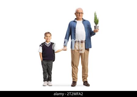 Portrait en longueur d'un écolier et père tenant un petit arbre dans un pot isolé sur fond blanc Banque D'Images