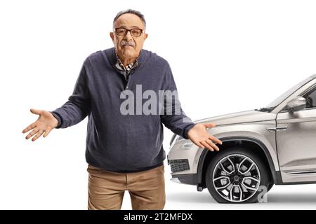 Homme mature malheureux debout devant un SUV avec pneu crevé isolé sur fond blanc Banque D'Images